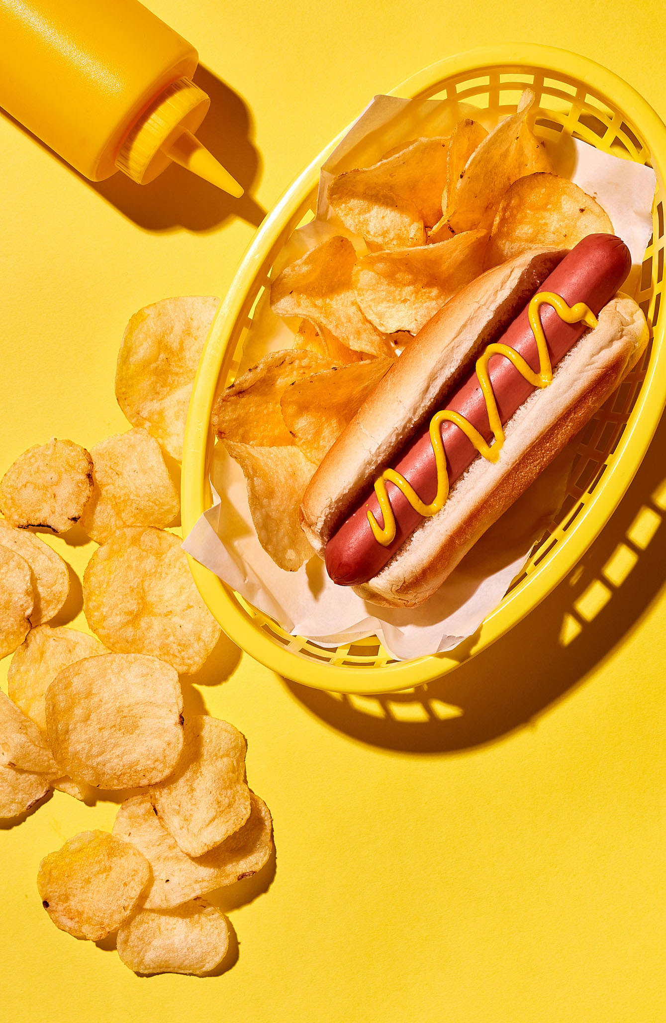 hot dog with mustard and potato chips
